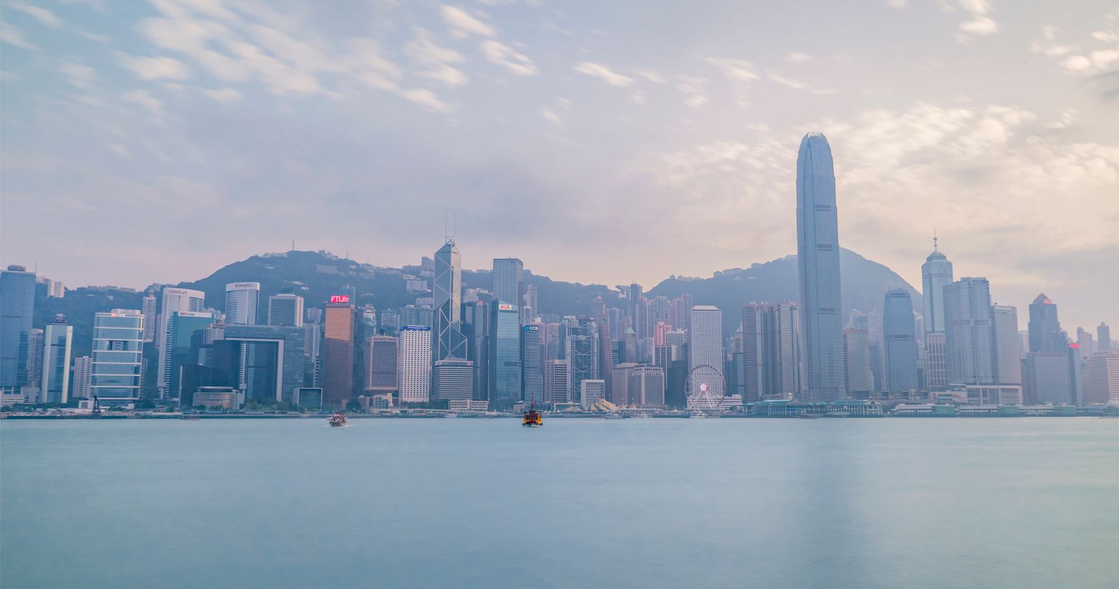 Hong Kong skyline with skyscrapers rising above Victoria Harbour in daylight