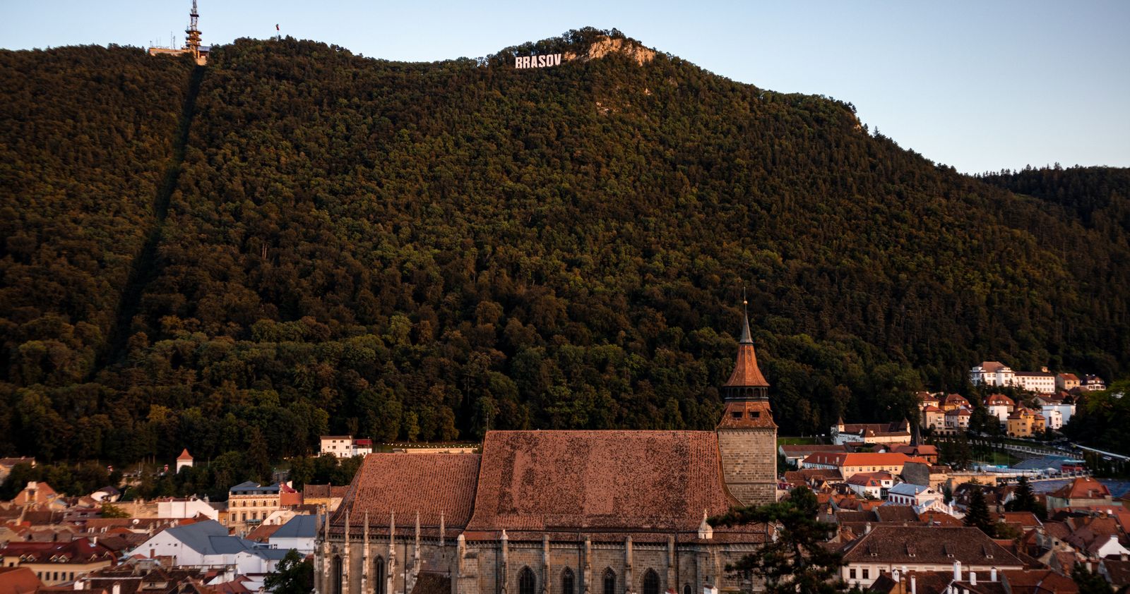 Aerial view of the historic old town of Brașov, Romania, with Mount Tâmpa at sunset